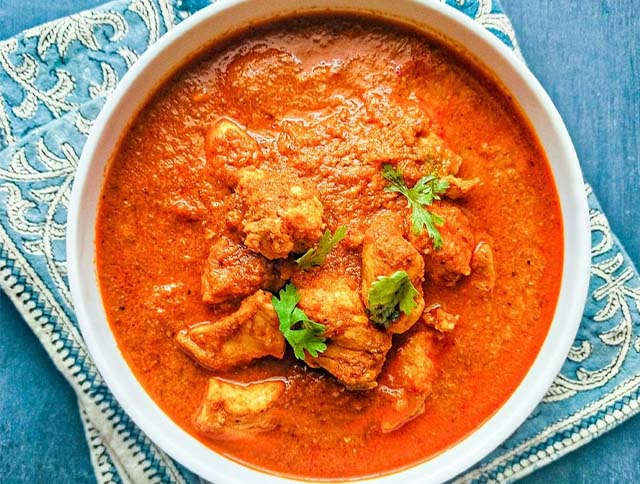 A plate of Chicken Xacuti, a spicy and aromatic Indian curry dish.