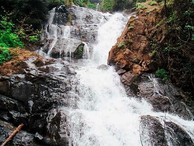 A breathtaking view of Tambdi Surla Waterfall in Goa during the monsoon season.